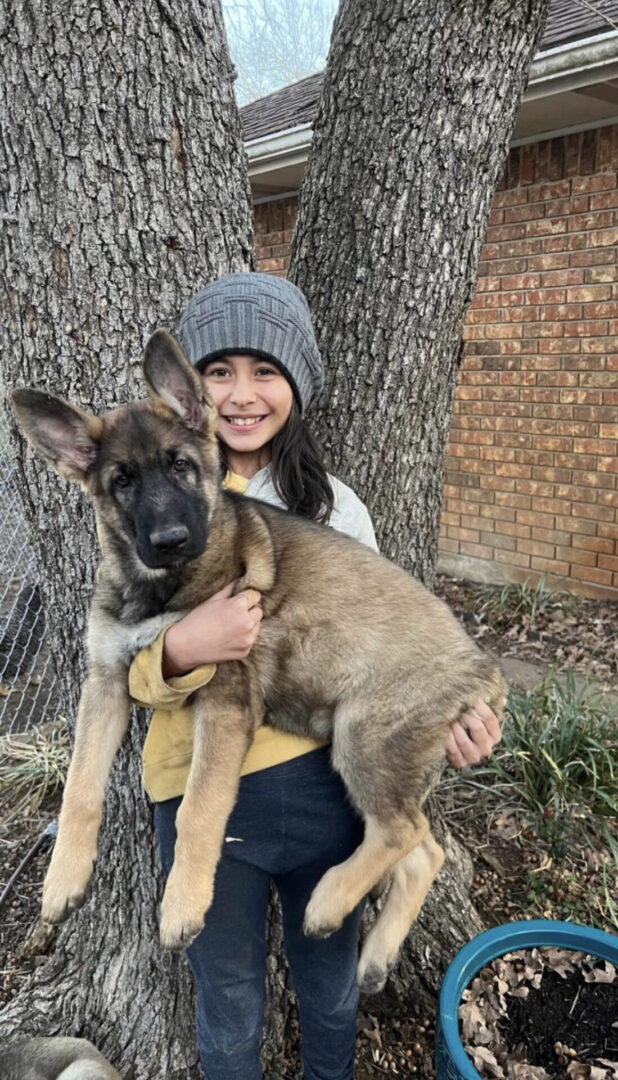 A girl holding a dog in her arms.